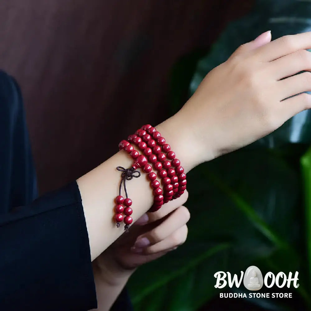 A BWOOOH Cinnabar 108 Mala Beads Blessing Bracelet, showcasing deeply engraved Om Mani Padme Hum mantra patterns on each bead, symbolizing spiritual protection and focus. - View 21