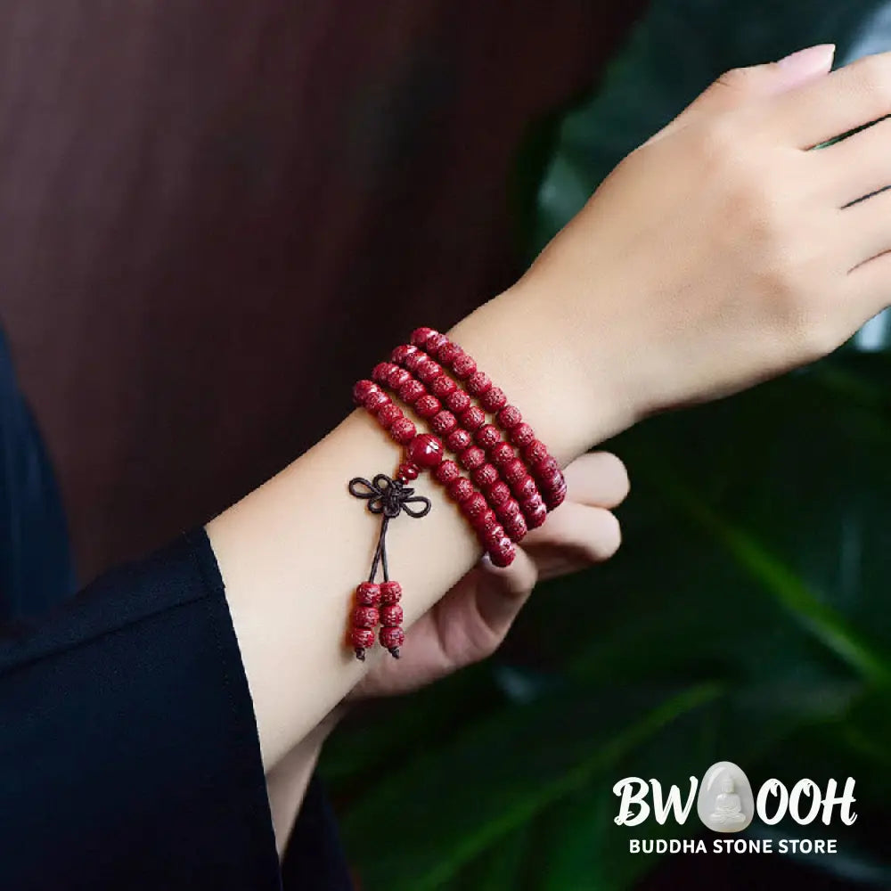 A BWOOOH Cinnabar 108 Mala Beads Blessing Bracelet, showcasing deeply engraved Om Mani Padme Hum mantra patterns on each bead, symbolizing spiritual protection and focus. - View 6