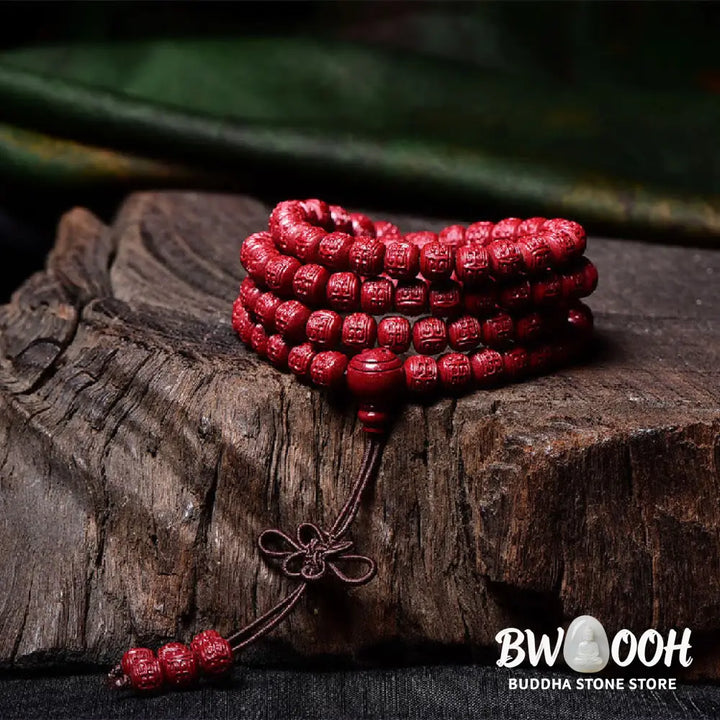 A BWOOOH Cinnabar 108 Mala Beads Blessing Bracelet, showcasing deeply engraved Om Mani Padme Hum mantra patterns on each bead, symbolizing spiritual protection and focus. - View 14