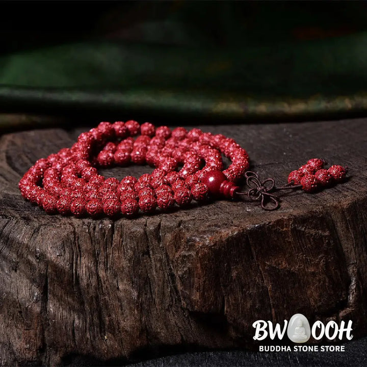 A BWOOOH Cinnabar 108 Mala Beads Blessing Bracelet, showcasing deeply engraved Om Mani Padme Hum mantra patterns on each bead, symbolizing spiritual protection and focus. - View 4