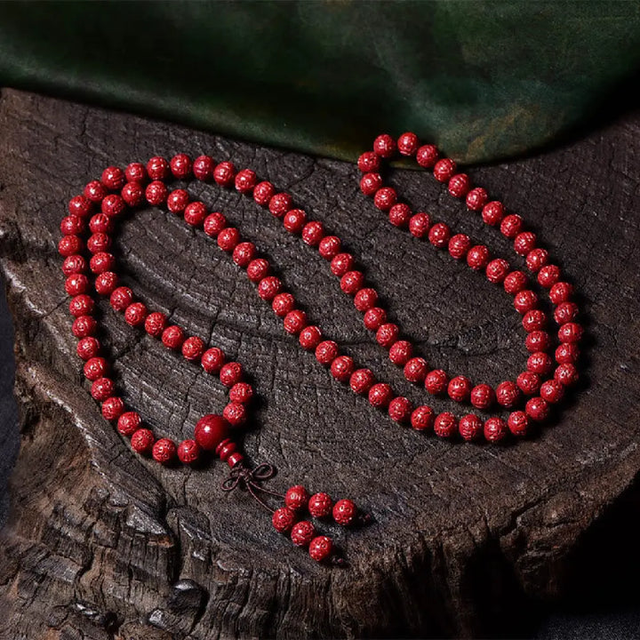 A BWOOOH Cinnabar 108 Mala Beads Blessing Bracelet, showcasing deeply engraved Om Mani Padme Hum mantra patterns on each bead, symbolizing spiritual protection and focus. - View 7