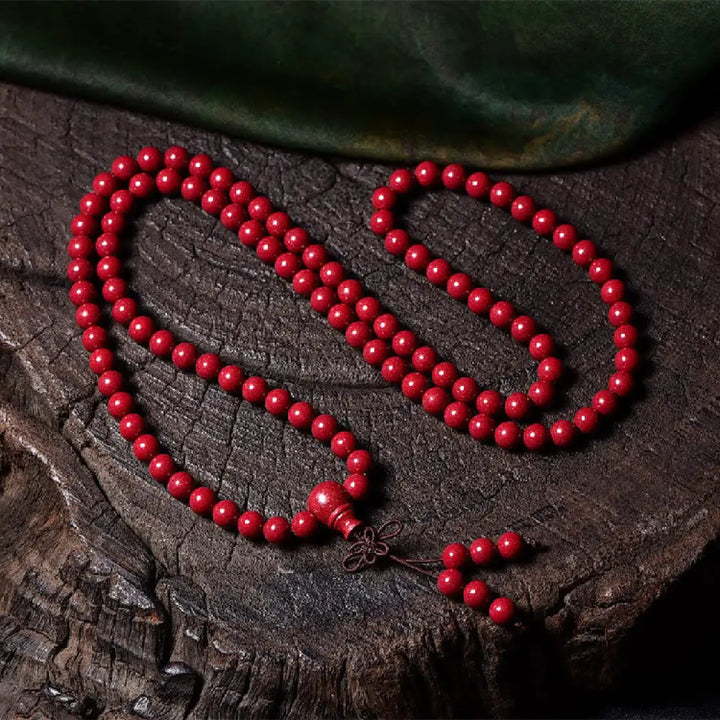 A BWOOOH Cinnabar 108 Mala Beads Blessing Bracelet, showcasing deeply engraved Om Mani Padme Hum mantra patterns on each bead, symbolizing spiritual protection and focus. - View 16