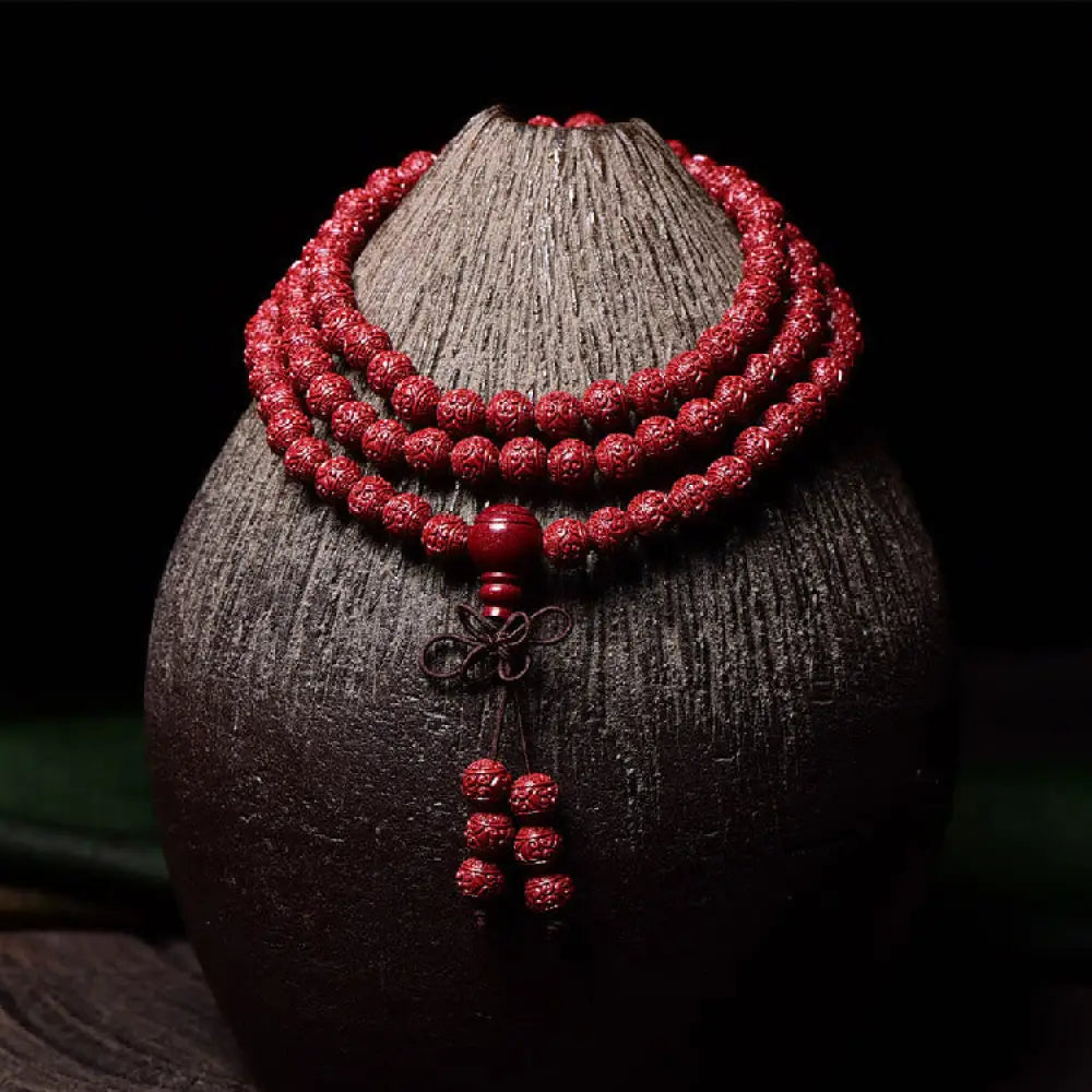 A BWOOOH Cinnabar 108 Mala Beads Blessing Bracelet, showcasing deeply engraved Om Mani Padme Hum mantra patterns on each bead, symbolizing spiritual protection and focus.
