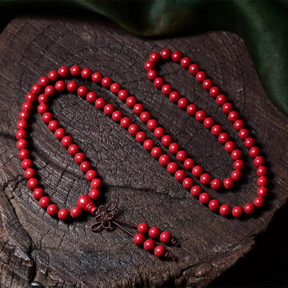 A BWOOOH Cinnabar 108 Mala Beads Blessing Bracelet, showcasing deeply engraved Om Mani Padme Hum mantra patterns on each bead, symbolizing spiritual protection and focus. - View 17