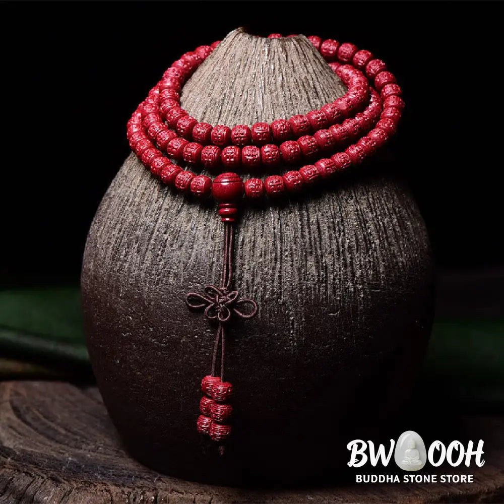 A BWOOOH Cinnabar 108 Mala Beads Blessing Bracelet, showcasing deeply engraved Om Mani Padme Hum mantra patterns on each bead, symbolizing spiritual protection and focus. - View 13