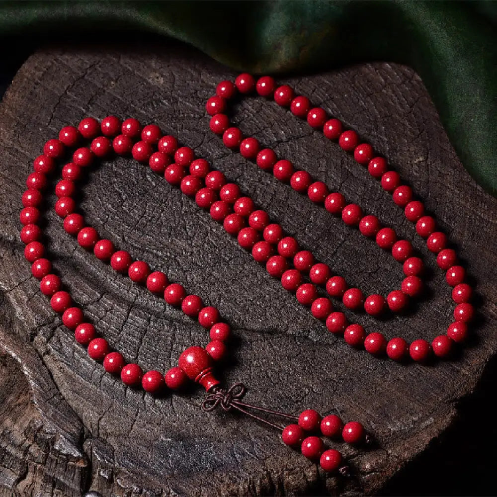 A BWOOOH Cinnabar 108 Mala Beads Blessing Bracelet, showcasing deeply engraved Om Mani Padme Hum mantra patterns on each bead, symbolizing spiritual protection and focus. - View 18