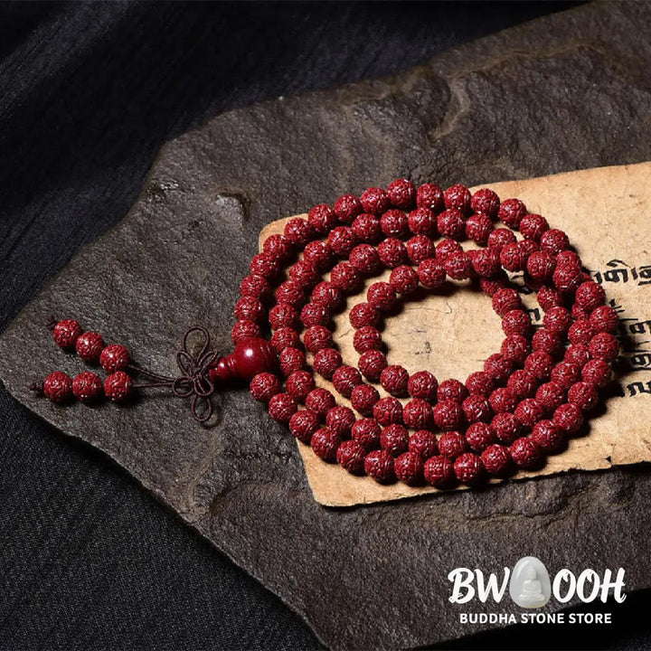 A BWOOOH Cinnabar 108 Mala Beads Blessing Bracelet, showcasing deeply engraved Om Mani Padme Hum mantra patterns on each bead, symbolizing spiritual protection and focus. - View 5