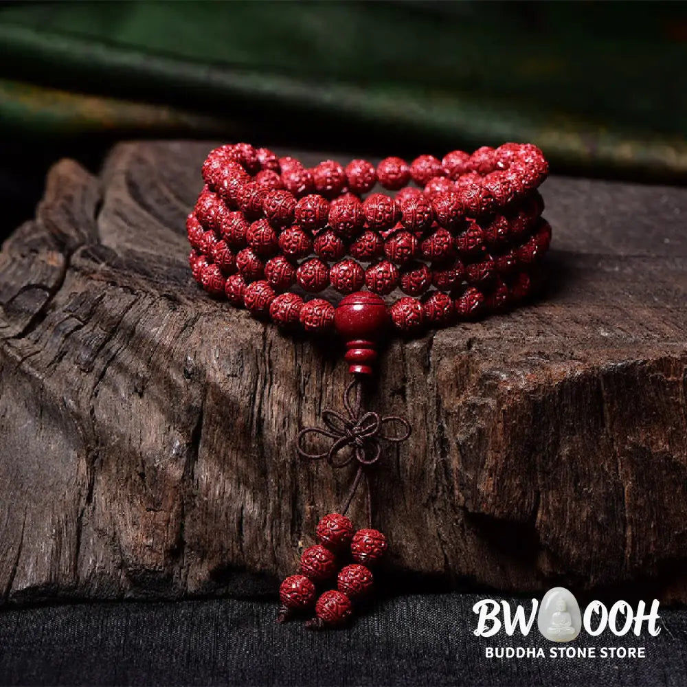 A BWOOOH Cinnabar 108 Mala Beads Blessing Bracelet, showcasing deeply engraved Om Mani Padme Hum mantra patterns on each bead, symbolizing spiritual protection and focus. - View 3