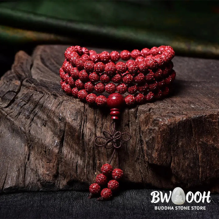 A BWOOOH Cinnabar 108 Mala Beads Blessing Bracelet, showcasing deeply engraved Om Mani Padme Hum mantra patterns on each bead, symbolizing spiritual protection and focus. - View 3