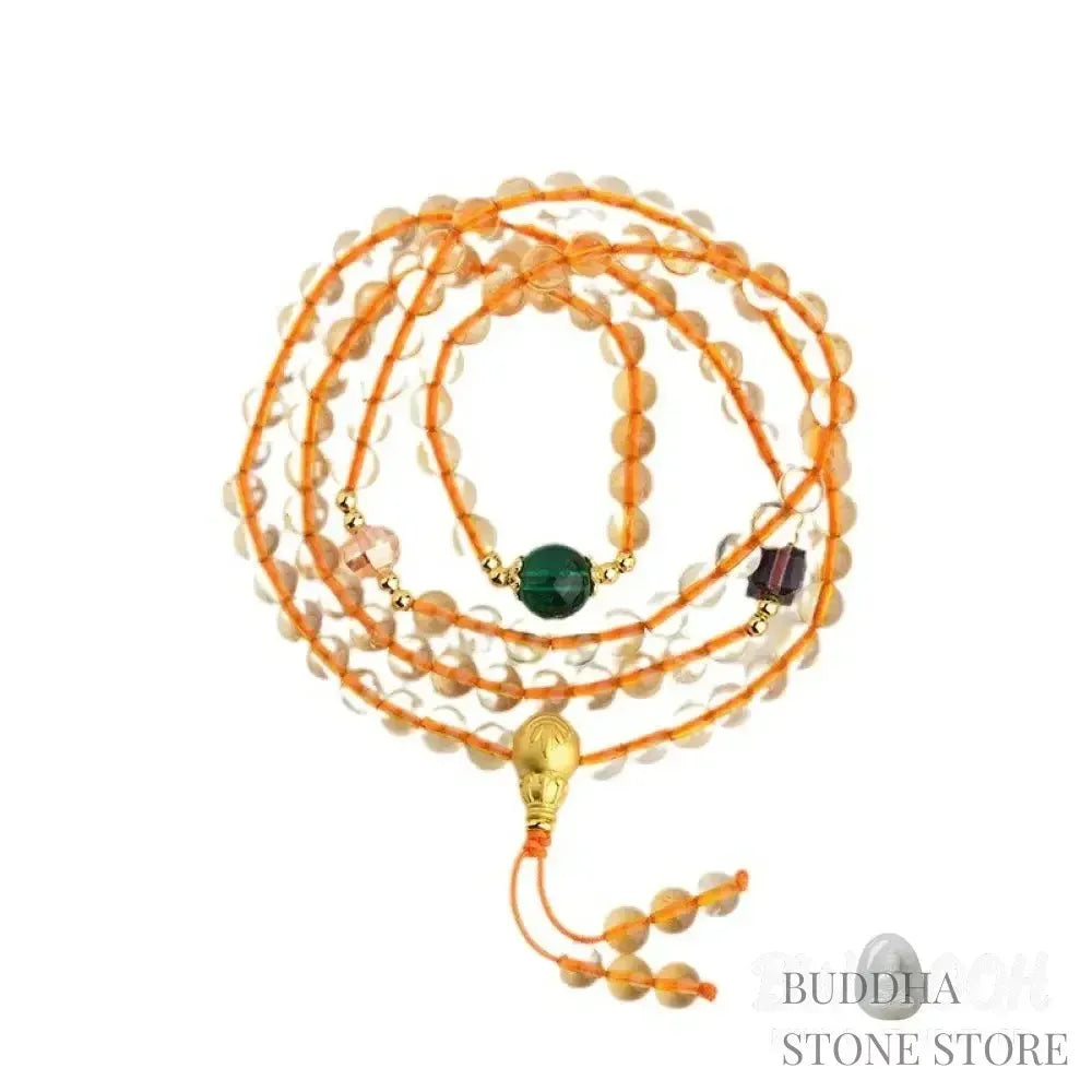 Main image of a BWOOOH 108 mala beads bracelet, crafted from polished natural citrine, with a prominent Liuli bead and alloy charm, resting on a serene, textured surface, ready for meditation and mindful reflection. - View 9