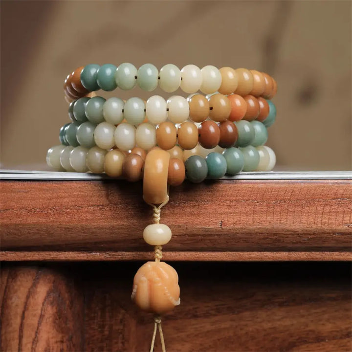 Close-up of BWOOOH 108 gradient Bodhi Seed mala beads, each hand-engraved with a subtle Buddha hand symbol, strung on an elastic peace bracelet, showcasing unique dark-speckled textures.