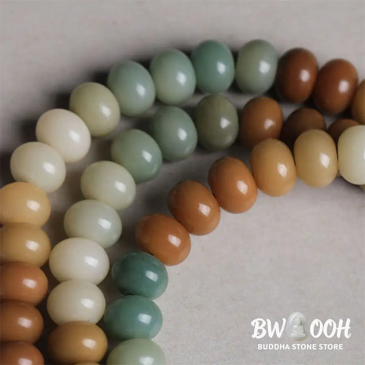 Close-up of BWOOOH 108 gradient Bodhi Seed mala beads, each hand-engraved with a subtle Buddha hand symbol, strung on an elastic peace bracelet, showcasing unique dark-speckled textures. - View 4