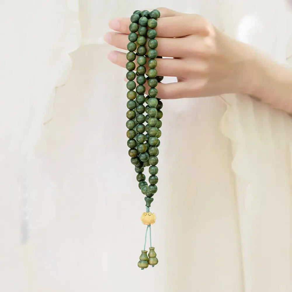 BWOOOH 108 mala beads bracelet crafted from natural green sandalwood and boxwood, featuring a distinct lotus symbol charm, designed for meditation, positive energy, and spiritual tranquility.
