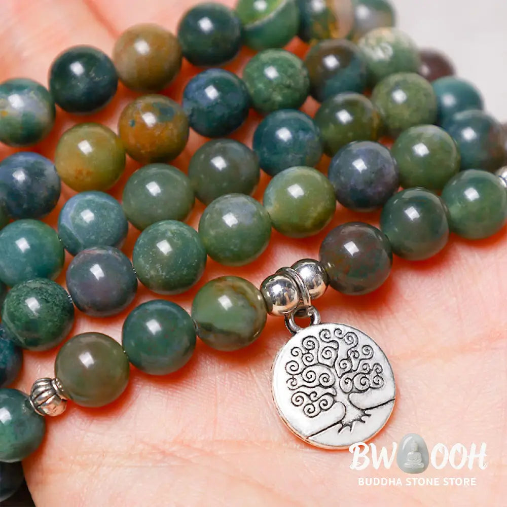 A BWOOOH 108 Indian Agate Mala Beads bracelet, featuring a prominent OM symbol charm, a serene Lotus charm, and a detailed Tree of Life charm, all strung on a premium elastic band, against a minimalist backdrop. - View 10