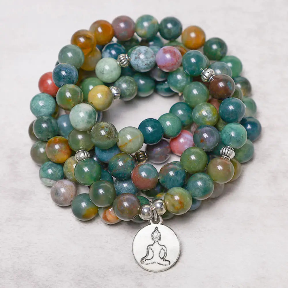 A BWOOOH 108 Indian Agate Mala Beads bracelet, featuring a prominent OM symbol charm, a serene Lotus charm, and a detailed Tree of Life charm, all strung on a premium elastic band, against a minimalist backdrop. - View 5