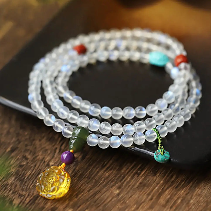 BWOOOH 108 Mala Beads bracelet handcrafted with shimmering Moonstone, warm Amber, vibrant Turquoise, and an engraved Lotus symbol, ideal for meditation and spiritual healing.