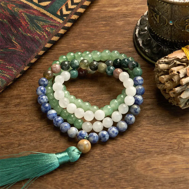 BWOOOH 108 Mala bracelet featuring 8mm natural Green Aventurine, Blue Spot Jasper, and Indian Agate beads with a vibrant green tassel, displayed on a meditation cushion, symbolizing luck, serenity, and balance for mindfulness practices.
