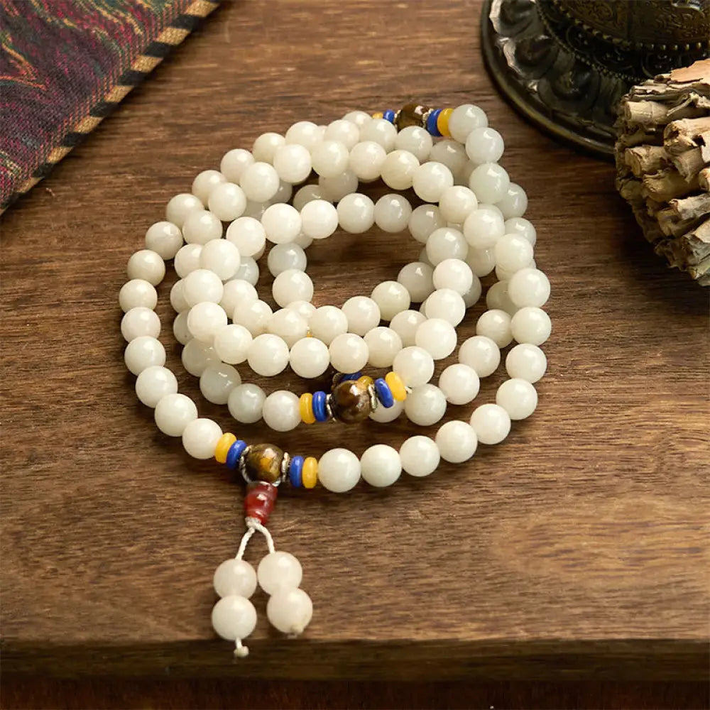A close-up of the BWOOOH 108 Mala Beads Natural Quartzite Wealth Luck Bracelet, featuring polished 8mm quartzite and tiger eye beads on an elastic string, subtly revealing variations in natural color, embodying spiritual balance and prosperity.
