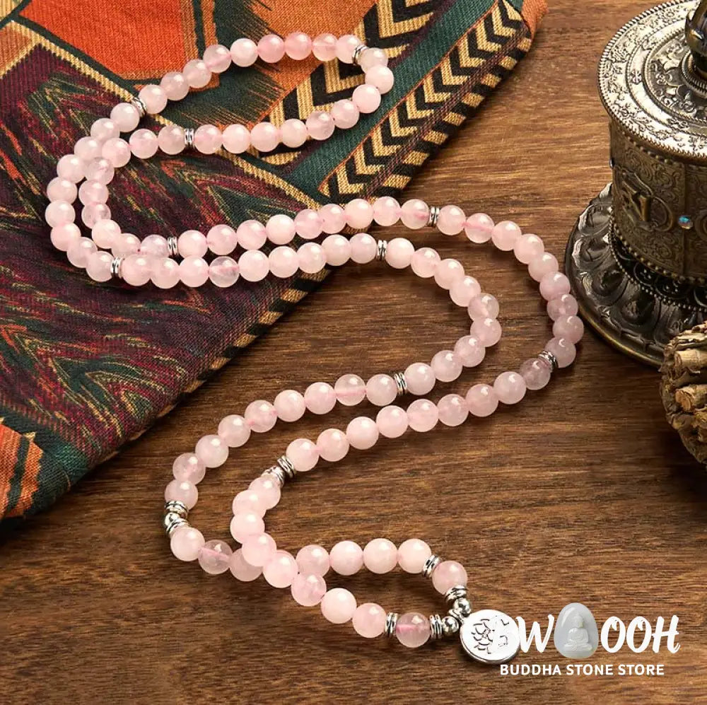 A BWOOOH Rose Quartz 108 mala bead bracelet with 8mm natural stones, featuring a round engraved lotus peace symbol pendant on a premium elastic string, ideal for meditation and emotional balance. - View 2