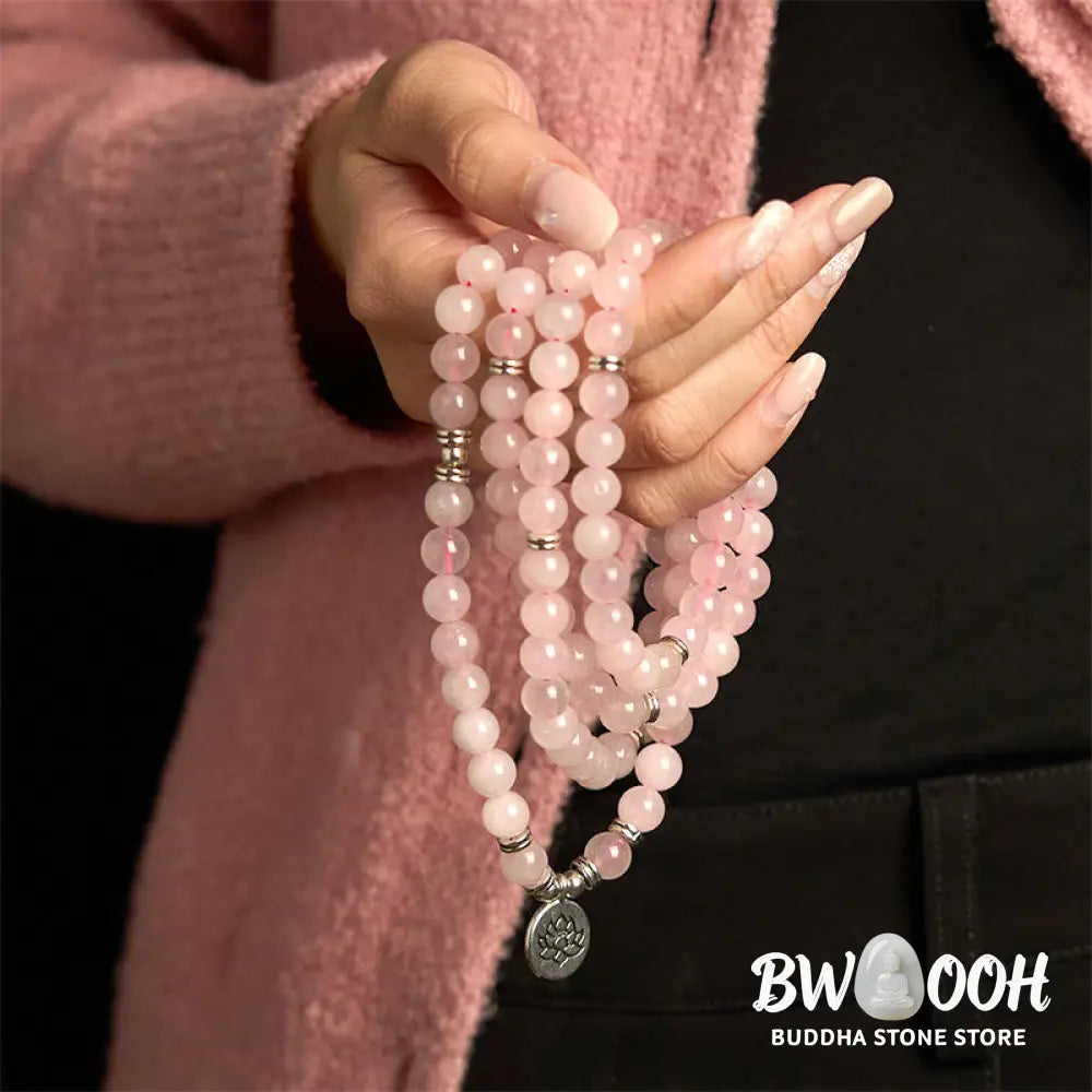 A BWOOOH Rose Quartz 108 mala bead bracelet with 8mm natural stones, featuring a round engraved lotus peace symbol pendant on a premium elastic string, ideal for meditation and emotional balance. - View 3