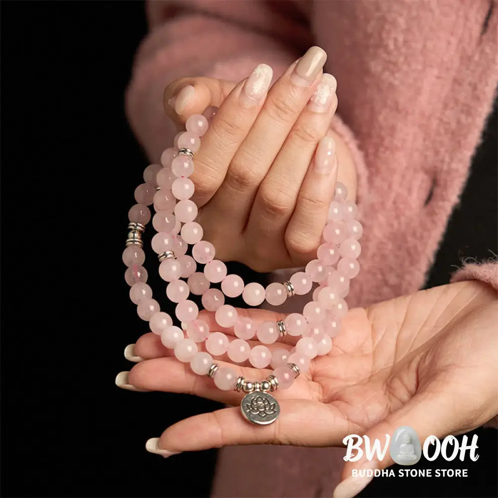 A BWOOOH Rose Quartz 108 mala bead bracelet with 8mm natural stones, featuring a round engraved lotus peace symbol pendant on a premium elastic string, ideal for meditation and emotional balance. - View 4