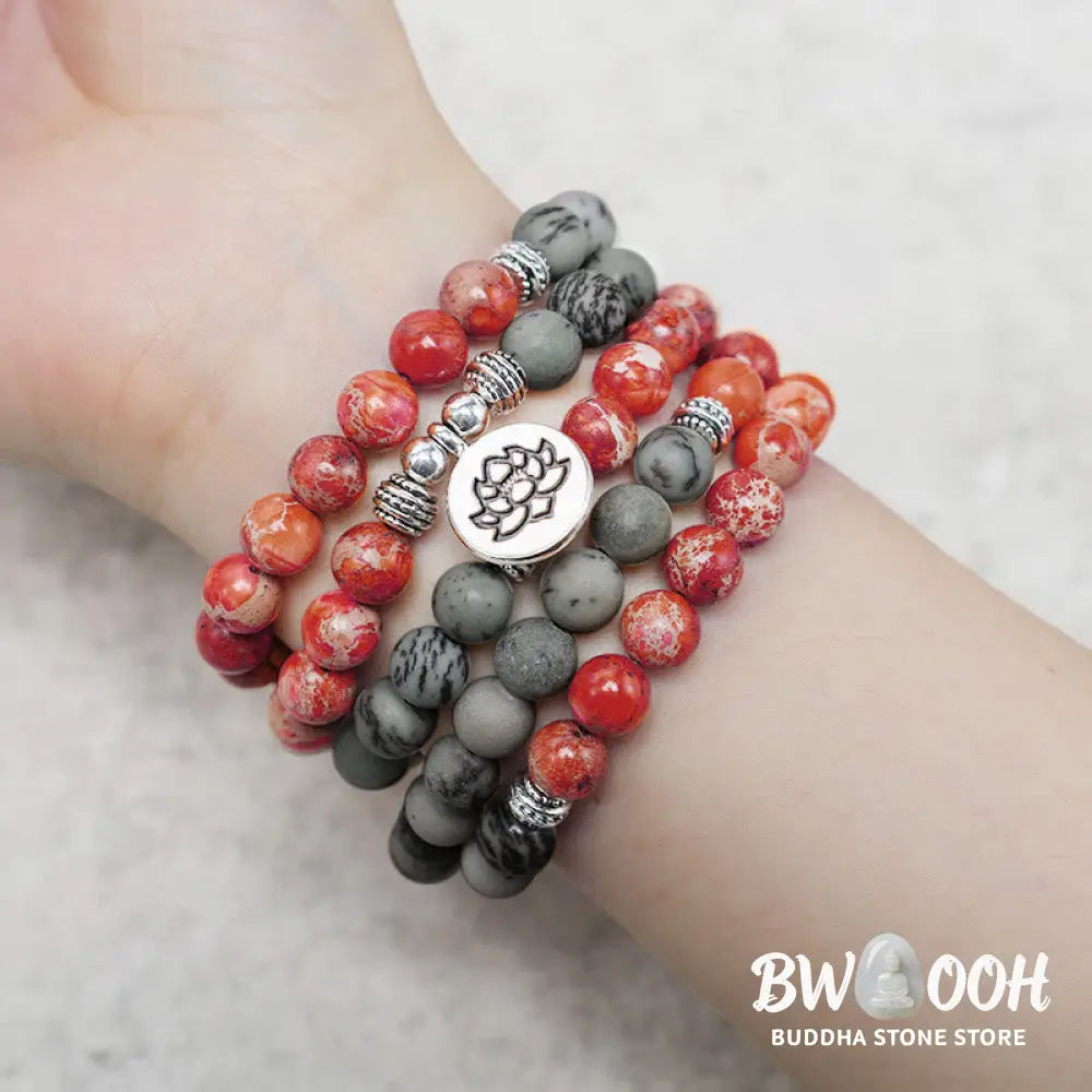 BWOOOH 108-bead Sea Sediment Jasper Lotus Protection Bracelet, displaying natural blue-green and orange Jasper beads with a silver-tone lotus charm, laid against a neutral background. - View 5