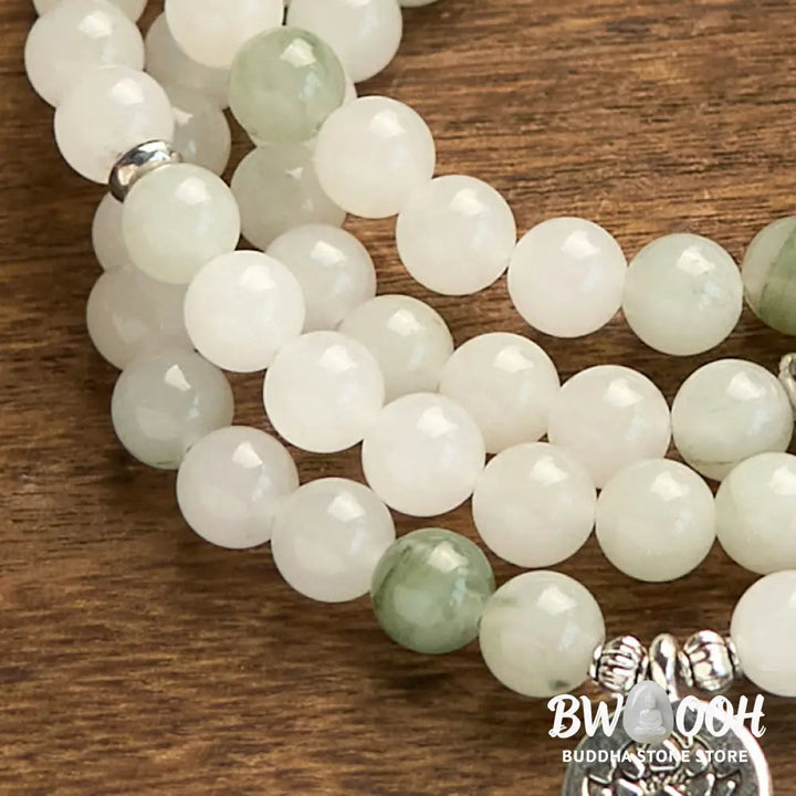 BWOOOH 108-bead Tianshan Jade Mala bracelet, handcrafted with 8mm calming green jade beads and an engraved silver-tone lotus charm on a premium elastic string, photographed against a minimalist backdrop, highlighting its spiritual elegance and detailed craftsmanship for meditation and mindful wear. - View 7