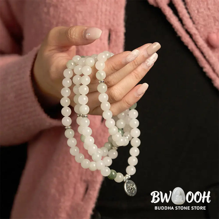 BWOOOH 108-bead Tianshan Jade Mala bracelet, handcrafted with 8mm calming green jade beads and an engraved silver-tone lotus charm on a premium elastic string, photographed against a minimalist backdrop, highlighting its spiritual elegance and detailed craftsmanship for meditation and mindful wear. - View 5