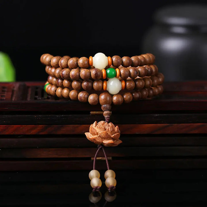 BWOOOH 108 Mala Beads handcrafted from natural Peach Wood and Bodhi Seeds, featuring a detailed Lotus charm, designed for mindful prayer and meditation.