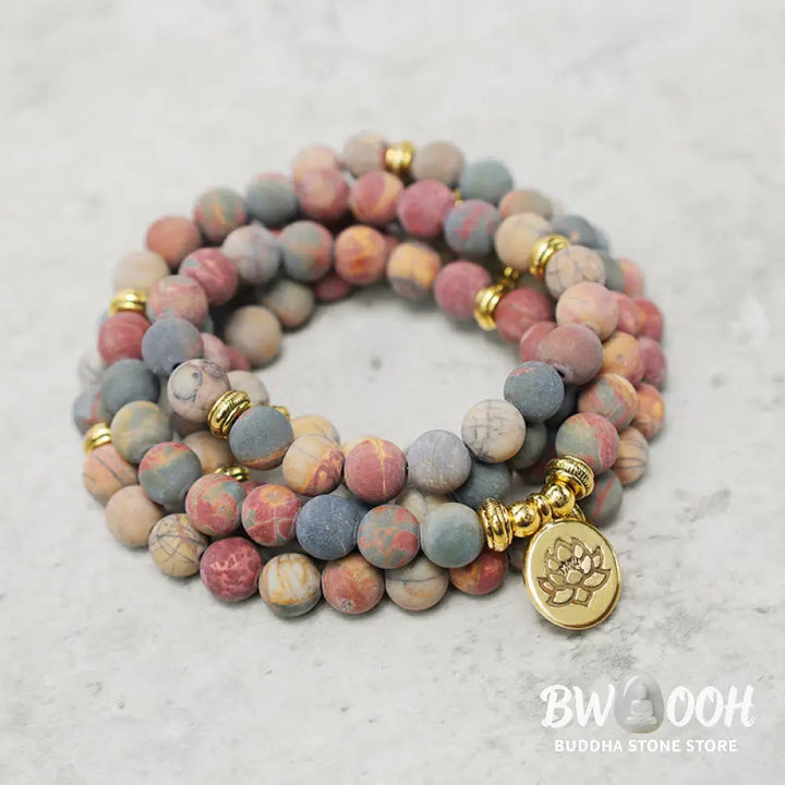 BWOOOH 108 Mala beads bracelet featuring naturally textured 8mm Picasso Jasper stones, accented with a delicate Lotus Symbol charm, symbolizing courage and spiritual resilience on an elastic band. - View 3