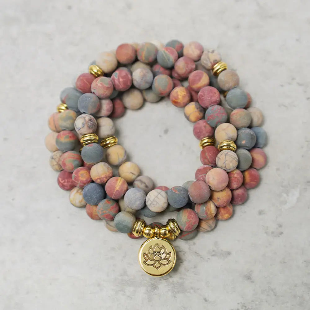 BWOOOH 108 Mala beads bracelet featuring naturally textured 8mm Picasso Jasper stones, accented with a delicate Lotus Symbol charm, symbolizing courage and spiritual resilience on an elastic band.
