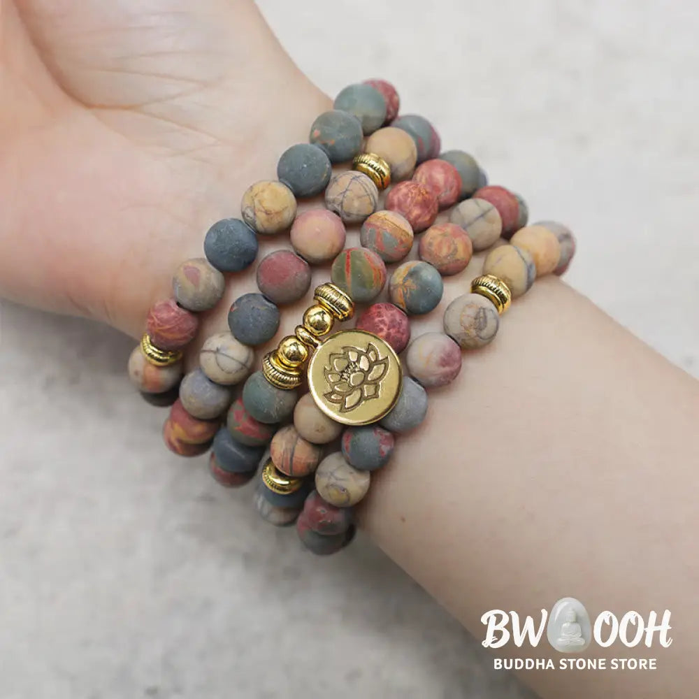 BWOOOH 108 Mala beads bracelet featuring naturally textured 8mm Picasso Jasper stones, accented with a delicate Lotus Symbol charm, symbolizing courage and spiritual resilience on an elastic band. - View 5