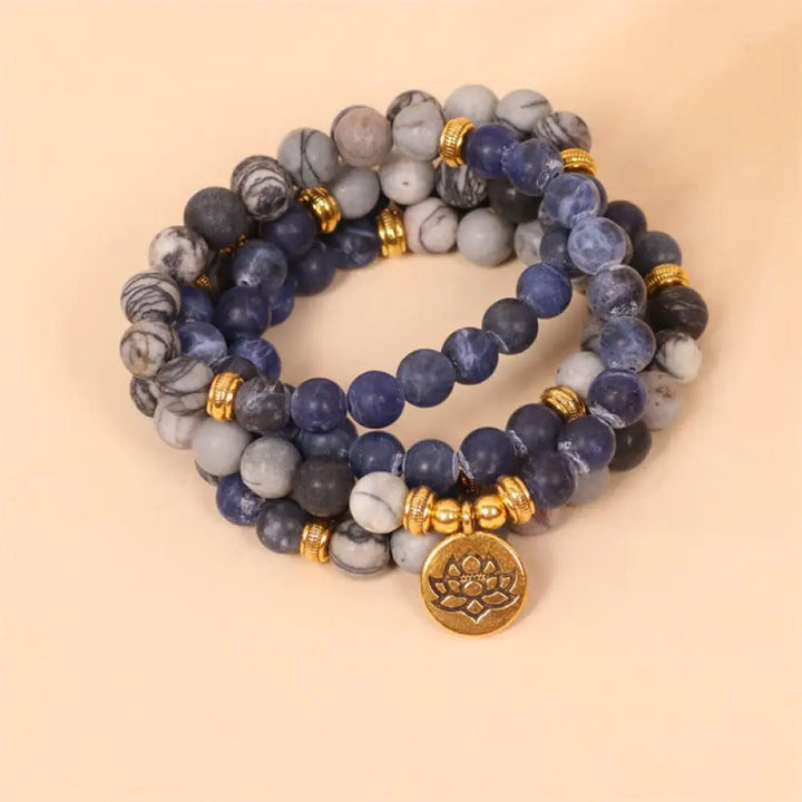 A BWOOOH 108-bead Mala bracelet featuring polished 8mm Sodalite and Zebra Jasper beads with a silver-toned alloy Lotus charm, strung on premium elastic.
