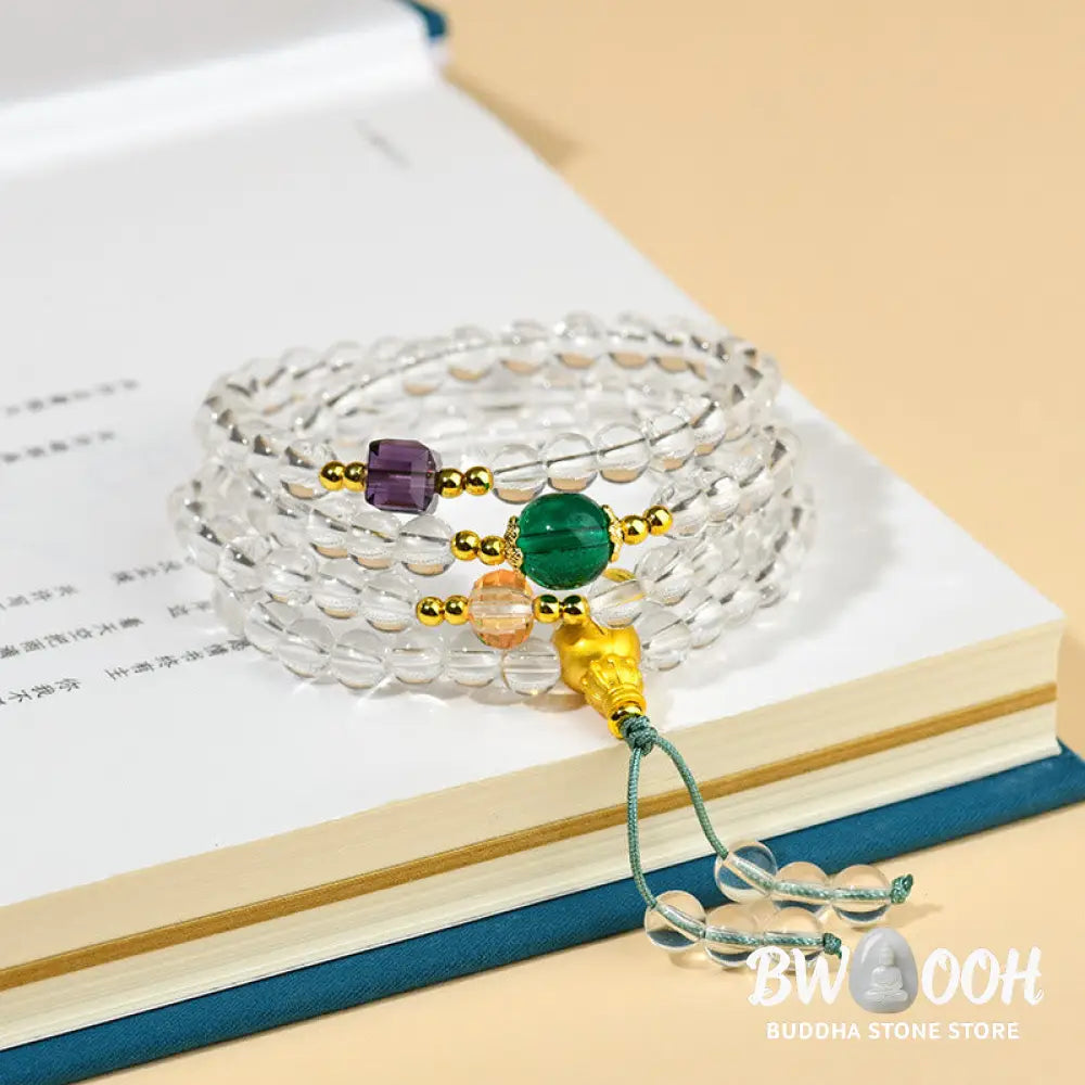 A close-up of the BWOOOH 108 Mala Beads White Crystal Clarity Bracelet, handcrafted with polished clear white crystal beads (7*9mm) on a premium elastic string, suitable for meditation and spiritual focus. The mala includes subtle alloy and Liuli accents, resting gently on a textured, serene background, highlighting its calming essence. - View 2