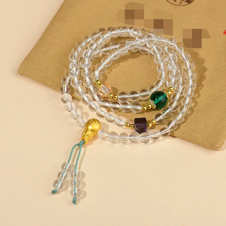 A close-up of the BWOOOH 108 Mala Beads White Crystal Clarity Bracelet, handcrafted with polished clear white crystal beads (7*9mm) on a premium elastic string, suitable for meditation and spiritual focus. The mala includes subtle alloy and Liuli accents, resting gently on a textured, serene background, highlighting its calming essence.