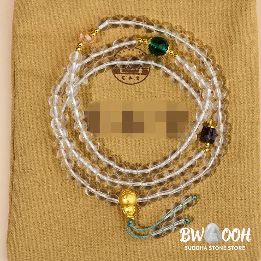 A close-up of the BWOOOH 108 Mala Beads White Crystal Clarity Bracelet, handcrafted with polished clear white crystal beads (7*9mm) on a premium elastic string, suitable for meditation and spiritual focus. The mala includes subtle alloy and Liuli accents, resting gently on a textured, serene background, highlighting its calming essence. - View 8
