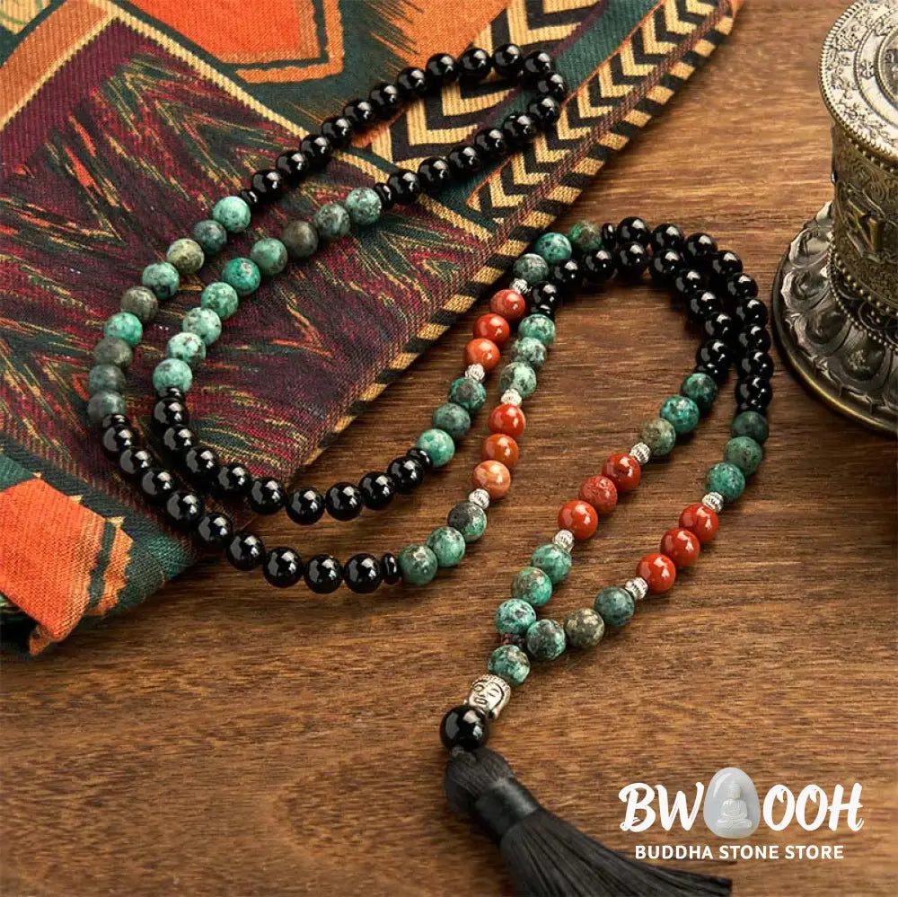 BWOOOH 108 Mala Protection Bracelet featuring 8mm natural Black Onyx, Red Jasper, and Turquoise beads, with a detailed Buddha Head charm and traditional tassel, displayed as a meditation accessory for spiritual balance and personal empowerment. - View 2