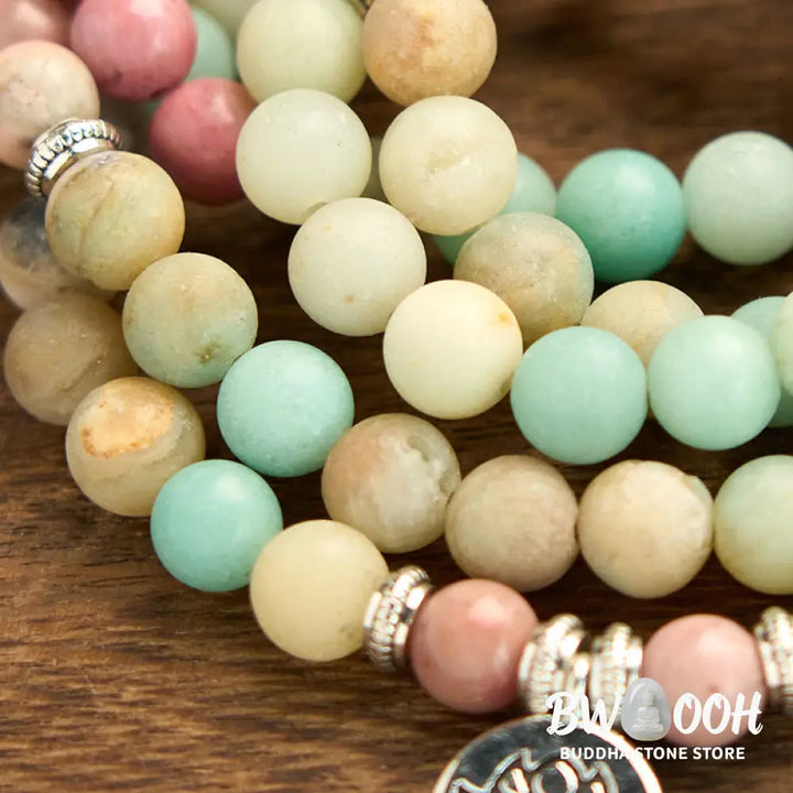 BWOOOH 108 Mala bracelet featuring polished 8mm Rhodonite and Amazonite beads, adorned with a round, intricately engraved Lotus charm, symbolizing compassion and inner harmony. - View 5