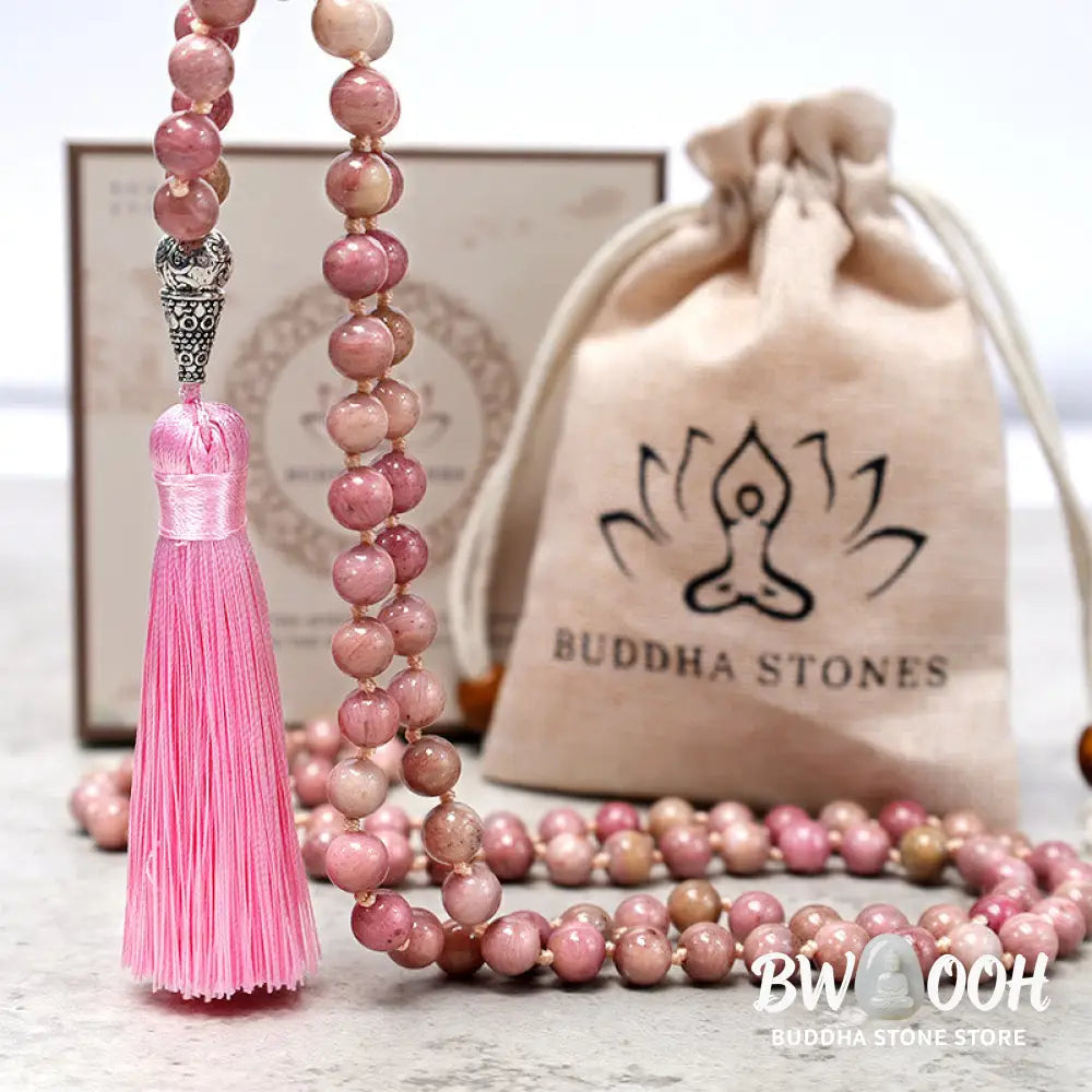 BWOOOH 108-bead Rhodonite Mala, a meditation bracelet or necklace featuring 8MM polished, natural pink rhodonite beads known for loving energy and healing properties, displayed on a tranquil surface. - View 6