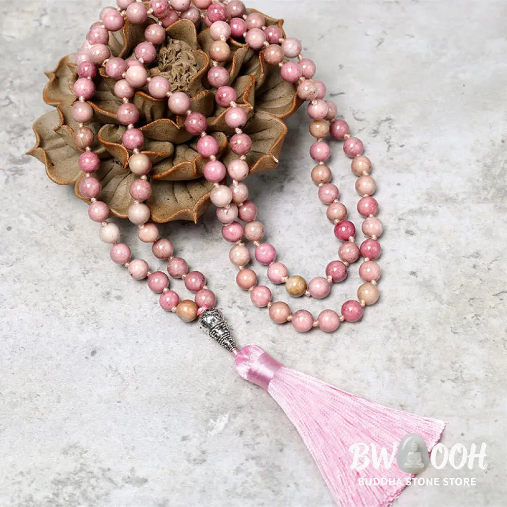 BWOOOH 108-bead Rhodonite Mala, a meditation bracelet or necklace featuring 8MM polished, natural pink rhodonite beads known for loving energy and healing properties, displayed on a tranquil surface. - View 2