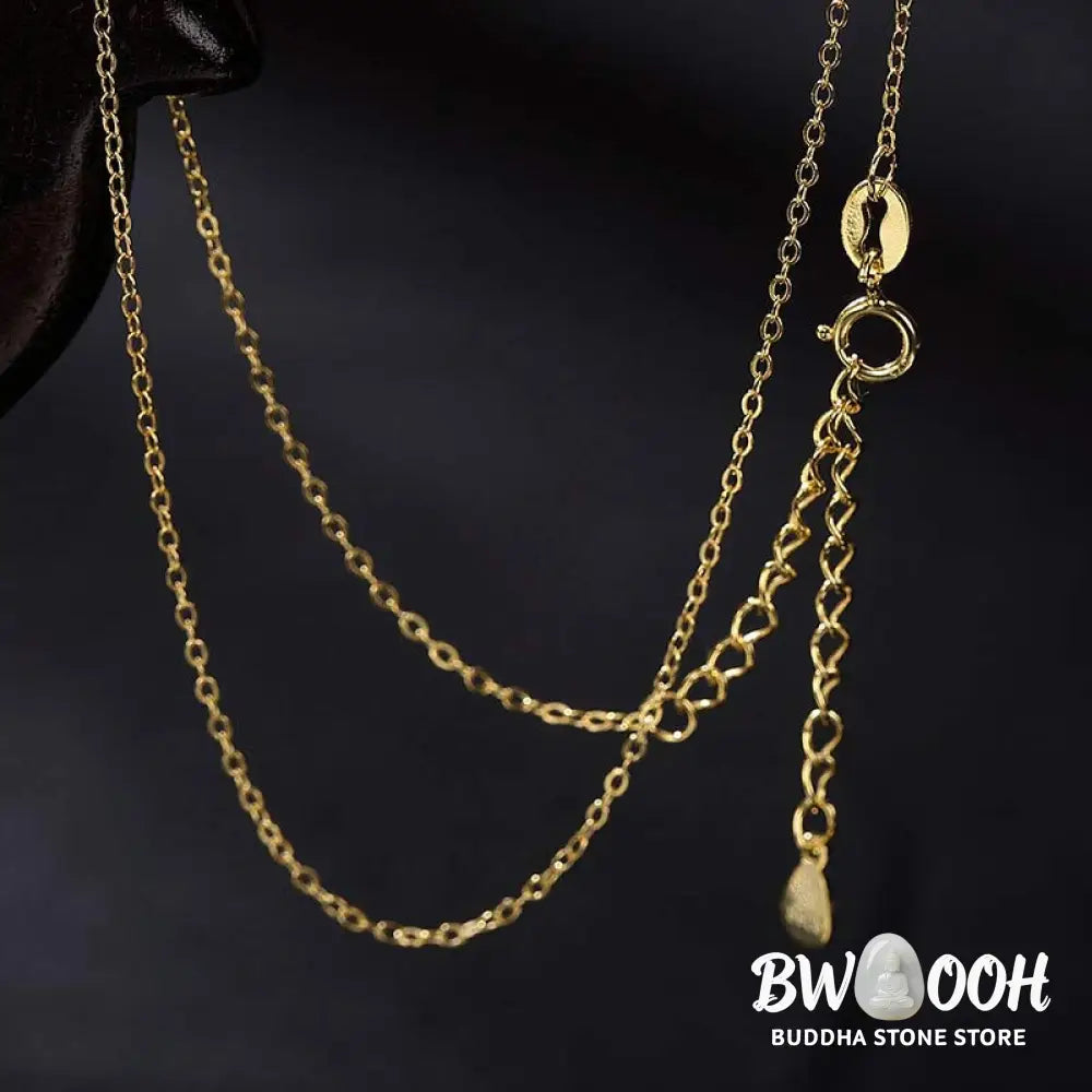 A close-up of the BWOOOH 925 Sterling Silver gold-plated elephant pendant, intricately carved and holding a vibrant jade stone, against a minimalist backdrop, highlighting its 45cm chain. - View 12