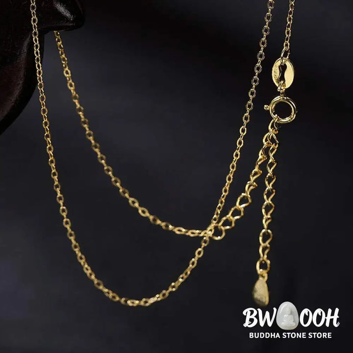 A close-up of the BWOOOH 925 Sterling Silver gold-plated elephant pendant, intricately carved and holding a vibrant jade stone, against a minimalist backdrop, highlighting its 45cm chain. - View 12