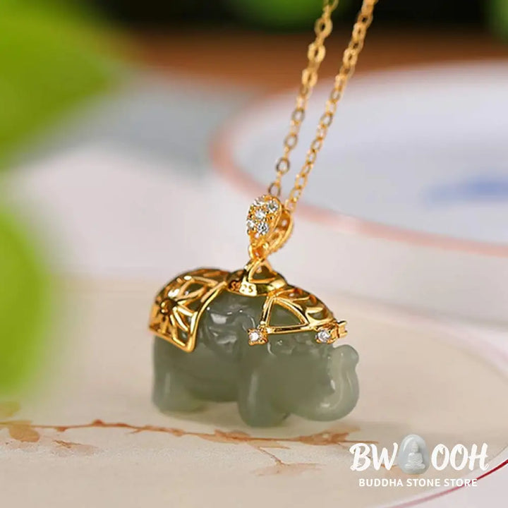 A close-up of the BWOOOH 925 Sterling Silver gold-plated elephant pendant, intricately carved and holding a vibrant jade stone, against a minimalist backdrop, highlighting its 45cm chain. - View 4