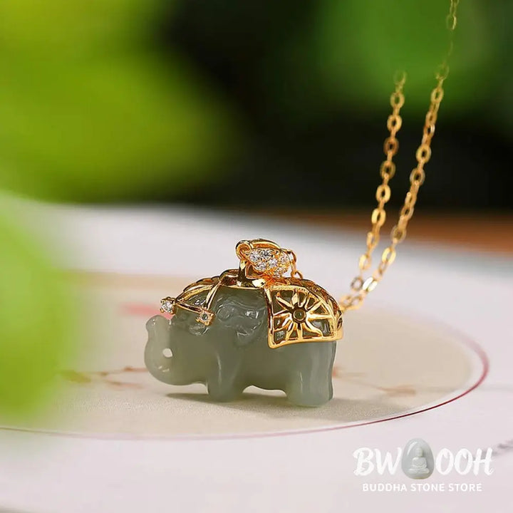 A close-up of the BWOOOH 925 Sterling Silver gold-plated elephant pendant, intricately carved and holding a vibrant jade stone, against a minimalist backdrop, highlighting its 45cm chain. - View 2