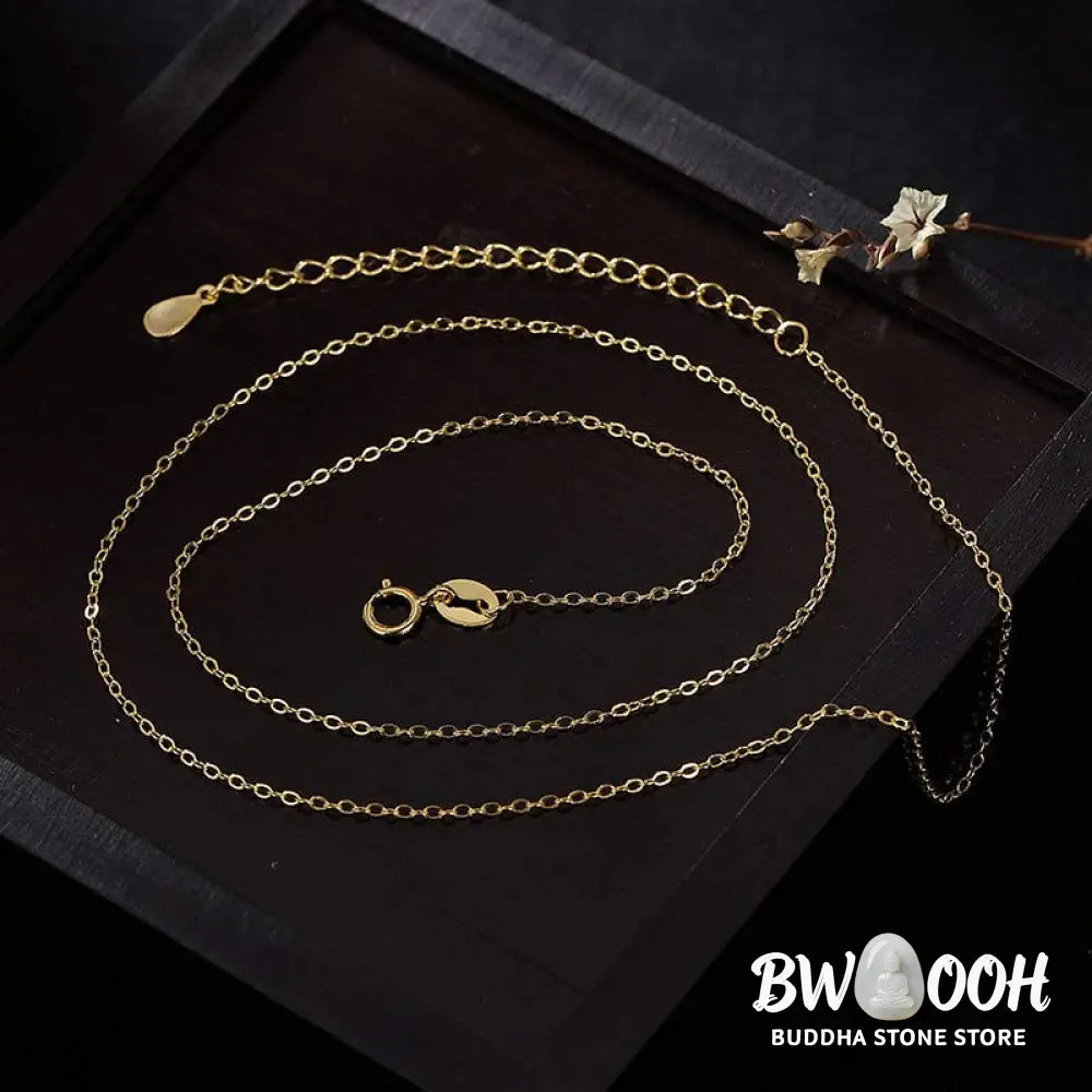A close-up of the BWOOOH 925 Sterling Silver gold-plated elephant pendant, intricately carved and holding a vibrant jade stone, against a minimalist backdrop, highlighting its 45cm chain. - View 11