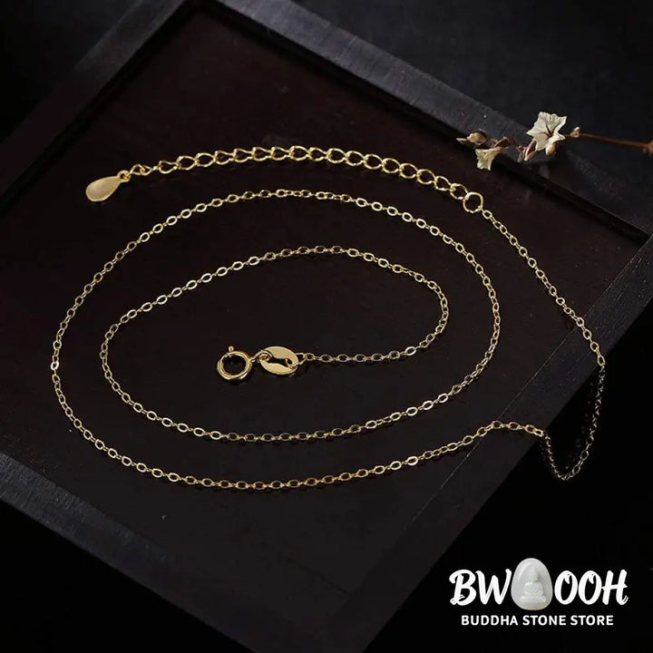A close-up of the BWOOOH 925 Sterling Silver gold-plated elephant pendant, intricately carved and holding a vibrant jade stone, against a minimalist backdrop, highlighting its 45cm chain. - View 11