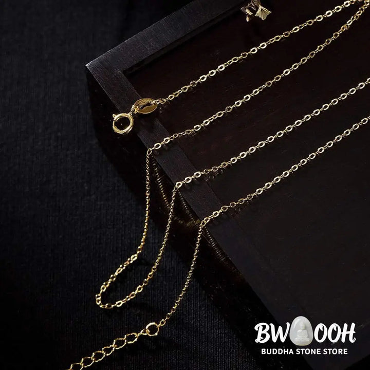 A close-up of the BWOOOH 925 Sterling Silver gold-plated elephant pendant, intricately carved and holding a vibrant jade stone, against a minimalist backdrop, highlighting its 45cm chain. - View 10