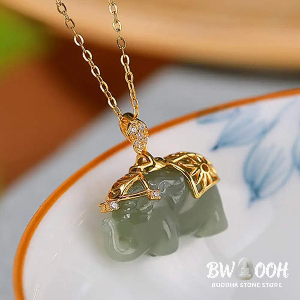 A close-up of the BWOOOH 925 Sterling Silver gold-plated elephant pendant, intricately carved and holding a vibrant jade stone, against a minimalist backdrop, highlighting its 45cm chain. - View 6