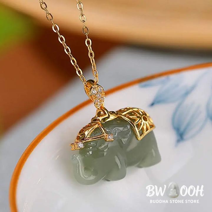 A close-up of the BWOOOH 925 Sterling Silver gold-plated elephant pendant, intricately carved and holding a vibrant jade stone, against a minimalist backdrop, highlighting its 45cm chain. - View 6