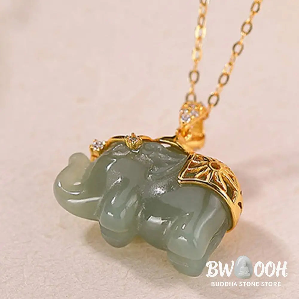 A close-up of the BWOOOH 925 Sterling Silver gold-plated elephant pendant, intricately carved and holding a vibrant jade stone, against a minimalist backdrop, highlighting its 45cm chain. - View 7